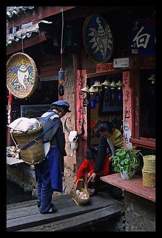 Naxi woman offers eggs for sale to local residents. Lijiang, Yunnan, China